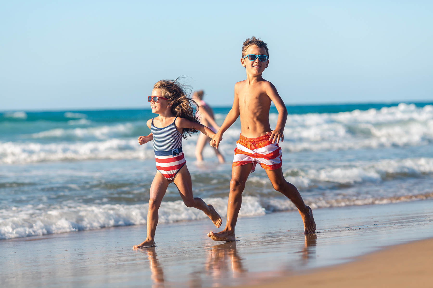 Girl and boy enjoys running on the beach