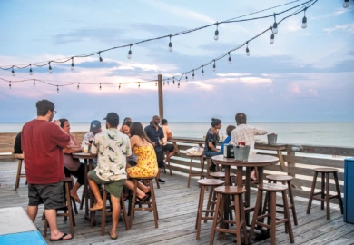 group of people eating outside on a deck