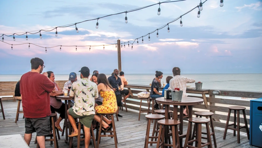 group of people eating outside on a deck