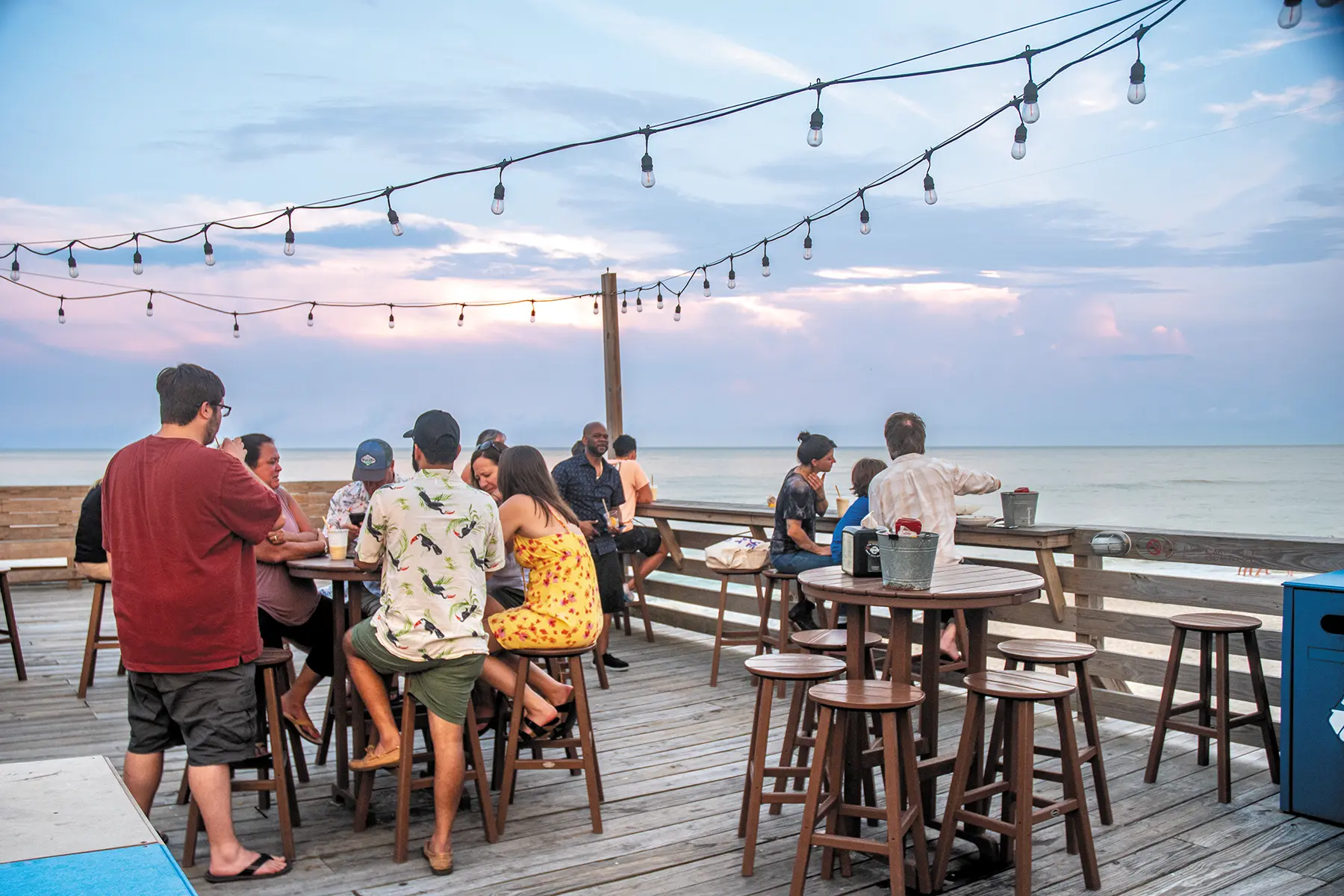 group of people eating outside on a deck